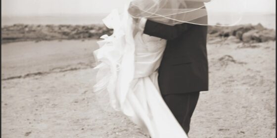 Wedding dress - groom carrying bride at the beach