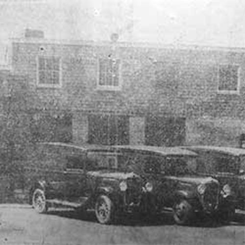 1920's era phot shows cars parked in front of Glynmore Lord Baltimore Cleaners