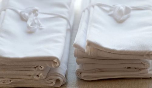 White linen napkins folded neatly and sitting on a table