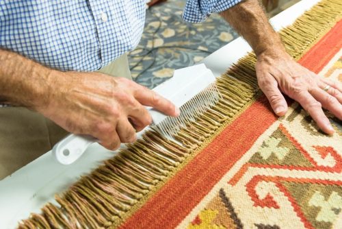 Rug-fringe repair - man combing rug fringe