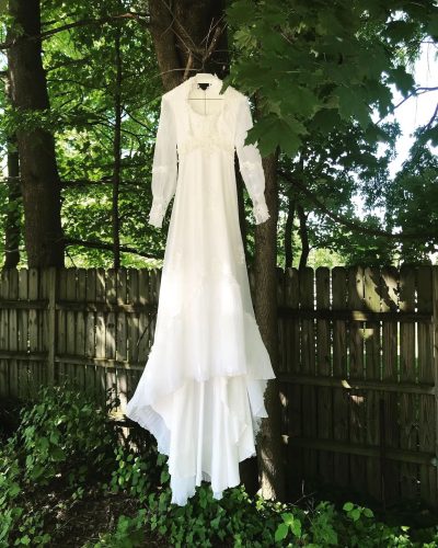 Wedding gown suspended artfully from a tree